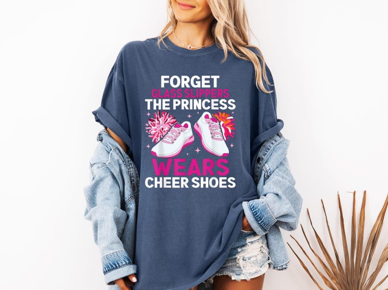 K&ouml;nnte beinhalten: Ein marineblaues T-Shirt mit einer Grafik von Cheerleader-Schuhen und dem Text "Forget glass slippers the princess wears cheer shoes".
