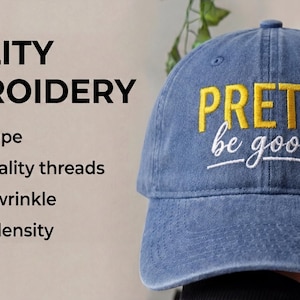 May include: A denim blue baseball cap with the embroidered text "PRETTI be good" in yellow and white. The image also shows text that says "QUALITY EMBROIDERY" and lists features like "Neat stripe" and "High-quality threads."