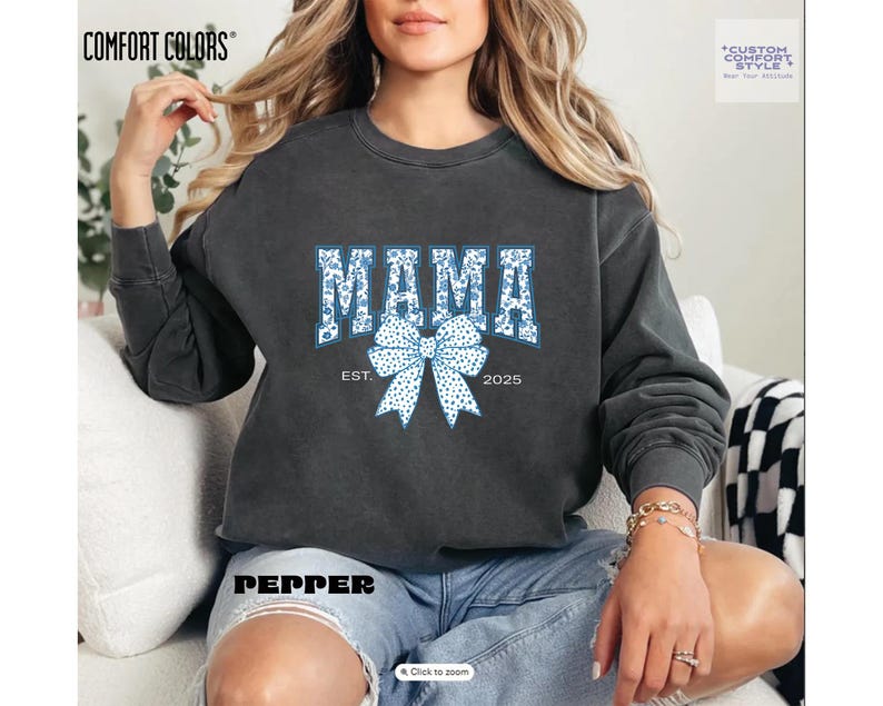 Elevate your style with this Custom Comfort Colors Mama Est Sweatshirt, a perfect blend of comfort and elegance. Designed with a Chinoiserie Blue Toile De Jouy pattern, this Coquette Bow Sweatshirt brings a timeless and feminine touch to any outfit. Whether you're looking for a girly aesthetic crewneck or a unique Mother's Day Gift, this Comfort Colors 1566 sweatshirt is a stylish and meaningful choice for moms.
Featuring a blue ribbon sweater design, this ribbon sweatshirt is inspired