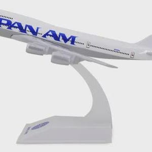 Può includere: Un modello di aereo bianco con il logo Pan Am in blu sulla fusoliera e sulla coda. Il modello è montato su un supporto bianco. La coda presenta il logo Pan Am e una piccola bandiera americana.
