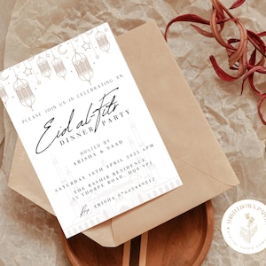 May include: A white invitation card with gold calligraphy that reads "Eid al-Fitr Dinner Party". The card features a decorative design of a mosque with lanterns and stars. The text includes the date, time, location, and contact information for the event.