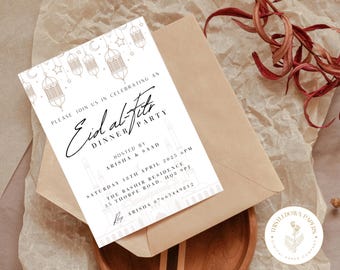 May include: A white invitation card with gold calligraphy that reads "Eid al-Fitr Dinner Party". The card features a decorative design of a mosque with lanterns and stars. The text includes the date, time, location, and contact information for the event.