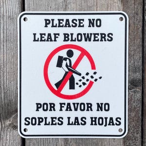 Señal de "Por favor, no sople las hojas" en blanco vibrante con letras negras, muy visible para interiores y exteriores.
