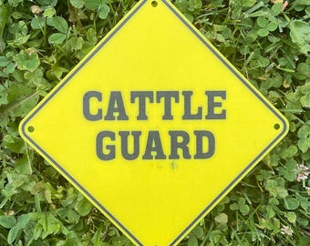 Señal de precaución de cruce de animales con diseño de diamante Cattle Guard en amarillo vibrante con letras negras, muy visible para interiores y exteriores, personalizable.