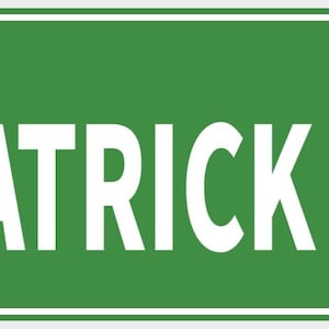 Pode incluir: Uma placa de rua verde com o texto branco "PATRICK DR". A placa tem uma borda branca e é montada com dois rebites prateados. As letras são em negrito e fáceis de ler.