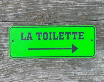 Französisches Schild ""La Toilette"" in leuchtendem Grün mit schwarzer Beschriftung