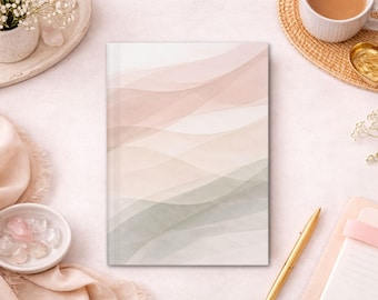 Peut inclure: Un journal à couverture rigide avec un motif aquarelle de couleurs pastel fluides et superposées. La couverture présente des nuances de rose, de pêche et de vert. Le journal est entouré d'objets décoratifs, dont une tasse de café et un stylo doré.
