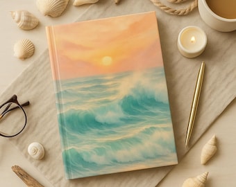 May include: A hardcover journal featuring a sunset over ocean waves in shades of orange, yellow, and teal. The journal is surrounded by seashells, a pen, a cup of coffee, a lit candle, and a piece of driftwood.