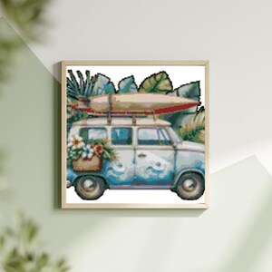 Könnte beinhalten: Ein blauer und weißer Vintage-Van mit einem Surfbrett auf dem Dach, umgeben von tropischen Pflanzen und Blumen. Der Van hat ein hölzernes Dachgepäckträger und einen Blumenstrauß im hinteren Fenster.