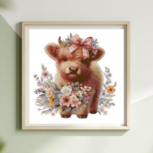 May include: A framed print featuring a watercolor illustration of a Highland cow calf. The calf is brown with a pink bow and floral crown. It is surrounded by a bouquet of pastel-colored flowers, set against a white background.