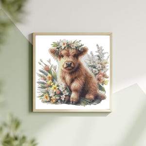 May include: A framed print featuring a watercolor illustration of a Highland cow calf. The calf has brown fur and wears a flower crown. It is surrounded by a bouquet of colorful flowers, including white, yellow, and pink blooms.