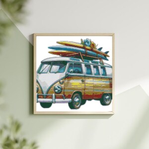 Könnte beinhalten: Ein Vintage-Campingbus in Weiß und Braun mit Surfbrettern auf dem Dach. Der Bus hat eine Blumenverzierung an der Front.