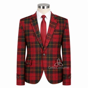 Puede incluir: Una chaqueta a cuadros rojos, negros y amarillos con una corbata roja a juego, exhibida en un maniquí. La chaqueta tiene un cierre de dos botones y un bolsillo en el pecho. La camisa blanca debajo contrasta con el atrevido patrón de cuadros. El logotipo de CelticCostume es visible.