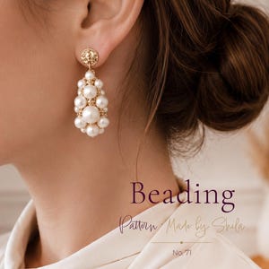 May include: A gold-toned drop earring featuring a cluster of white spherical pearls of varying sizes, suspended from a circular textured gold stud. The text Beading Pattern Made by Shila No. 71 is visible in the lower portion of the image.