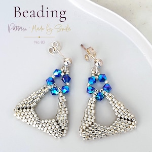 May include: A pair of drop earrings featuring a triangular frame made of metallic silver seed beads. Each earring includes a cluster of faceted, iridescent blue crystal beads at the top, connected to a silver post backing. Text reads Beading Pattern Made by Shila No. 83.
