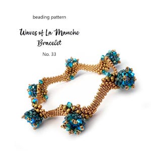 K&ouml;nnte beinhalten: Ein goldfarbenes Perlenarmband mit t&uuml;rkisfarbenen und blauen Perlenclustern. Das Armband tr&auml;gt die Aufschrift "Waves of La Manche Bracelet" und "No. 33". Das Design weist ein gewebtes Muster auf.