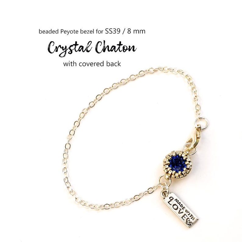 May include: A silver chain bracelet with a blue crystal chaton pendant and a charm that says "MADE WITH LOVE".