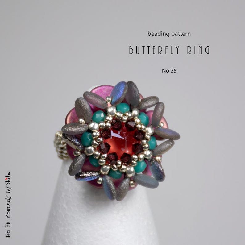 Puede incluir: Un anillo de cuentas con un dise&ntilde;o de mariposa. El anillo presenta una gema roja central rodeada de cuentas turquesas y plateadas, con cuentas iridiscentes grises y azules en forma de p&eacute;talo. El texto "Butterfly Ring" y "No 25" son visibles.