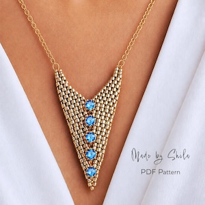 Pode incluir: Colar de contas douradas com um pendente em forma de V, adornado com cinco pedras azuis. O colar é suspenso por uma delicada corrente dourada. O texto "Made by Shila" e "PDF Pattern" são visíveis.
