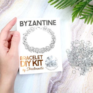 May include: Byzantine bracelet DIY kit by Streetmaille. The kit includes a white card with a silver bracelet design, a pile of silver jump rings, and a clasp. The text "Byzantine" and "Bracelet DIY Kit" are visible on the card.