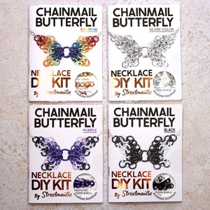 A photo of four of the butterfly kit colors including: Rainbow, starting with red on the wingtips and moving through the rainbow to purple in the center. Silver, a simple silver anodized aluminum butterfly. Purple, a mostly purple butterfly with lighter purple and black wing tips with white spots. Black, a mostly black butterfly with speckled white wingtips.