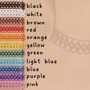 A stack of all the solid color oversized tattoo choker options including: black, white, brown, red, orange, yellow, green, light blue, blue, purple, and pink.