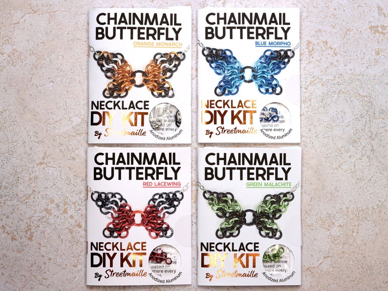 A photo of four of the butterfly kit colors including: Orange monarch, a mostly orange butterfly with black wing tips with white spots. Blue Morpho, a mostly blue butterfly with darker blue to black wingtips. Red Malachite, a mostly red butterfly with black wing tips with white spots. Green Malachite, a butterfly with a mixture of light green and black spread across the wings.