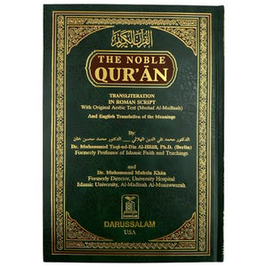 May include: A dark green hardcover book titled "The Noble Qur'an" with gold detailing. The book features transliteration in Roman script, original Arabic text, and English translation of the meanings.