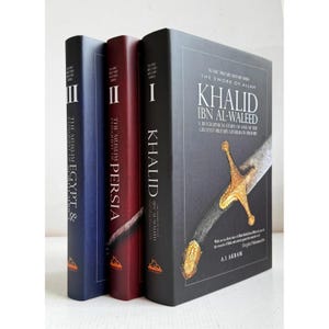 May include: A set of three hardcover books from the Islamic Military History Series. The black front book features a gold sword illustration and the title Khalid Ibn Al-Waleed. The spines are labeled I, II, and III, with titles including Persia and Egypt.