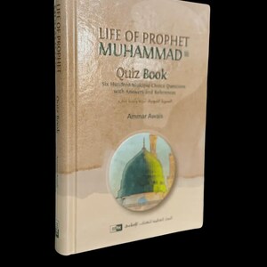 Può includere: Un libro con copertina rigida intitolato "Life of Prophet Muhammad Quiz Book" con testo in inglese e arabo. Il libro presenta un'illustrazione verde e bianca di una moschea sulla copertina. Il dorso recita "Life of Prophet" e "Quiz Book".