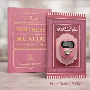 Könnte beinhalten: Ein rosa Buch mit dem Titel "Fortress of the Muslim" mit goldfarbenen Buchstaben, neben einem rosa Gebetsteppich mit einem digitalen Tasbih-Zähler. Das Buch stammt von Darussalam International. Das Bild enthält den Text "Free Tasbeeh Gift".