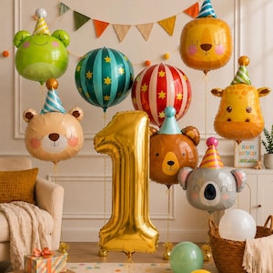 May include: A collection of foil balloons including a large gold number one, animal faces like a frog, lion, bear, giraffe, and koala wearing party hats, and round striped balloons. A colorful bunting banner hangs in the background.