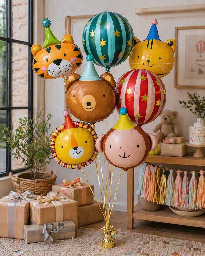 May include: A collection of animal-shaped foil balloons, including a tiger, bear, lion, and monkey, each wearing a party hat. Other balloons feature striped and star patterns. The balloons are tied together with gold ribbons, perfect for a birthday party.