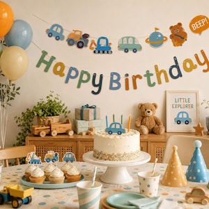 Op de afbeelding: Een feestelijke verjaardagsscène met ballonnen, een banner met de tekst "Happy Birthday" en een taart met kaarsen. De decoraties omvatten speelgoedauto's en een "Little Explorer"-afdruk. Een teddybeer en cupcakes zijn ook aanwezig.