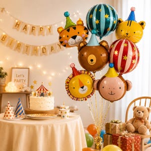 May include: A festive birthday scene with animal-shaped balloons, including a tiger, bear, lion, and monkey, alongside a striped balloon. A cake with a circus tent topper sits on a table with party hats and a banner that says "Happy Birthday."