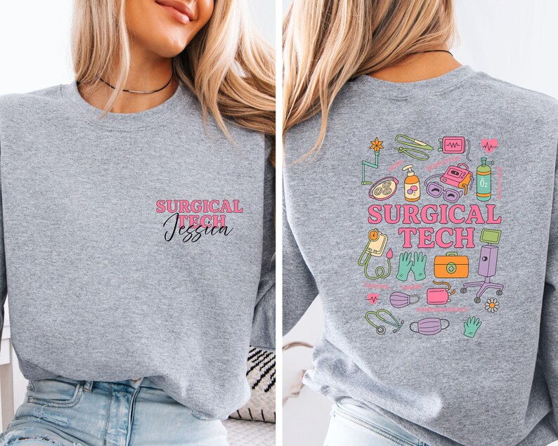 May include: A heather gray sweatshirt with the text "SURGICAL TECH Jessica" in pink and black on the front. The back features a colorful graphic of surgical tools and the words "SURGICAL TECH" in pink.