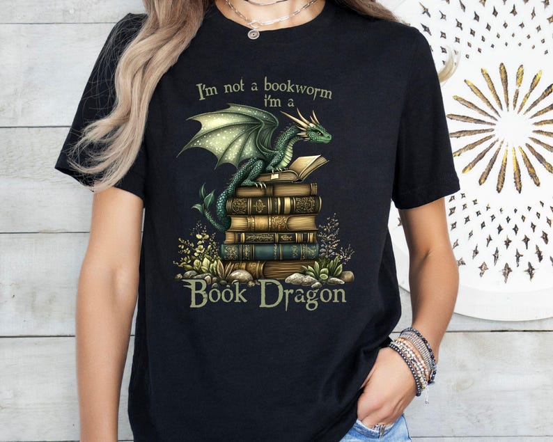 May include: Black t-shirt with a green dragon holding a stack of books. The text on the shirt reads "I'm not a bookworm I'm a Book Dragon".