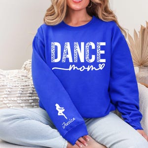 May include: A royal blue sweatshirt with the text "DANCE mom" in white with a leopard print pattern. The text "Jessica" is on the left sleeve.
