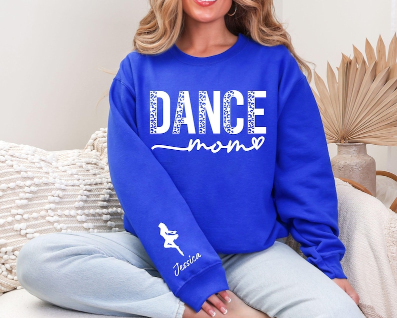 May include: A royal blue sweatshirt with the text "DANCE mom" in white with a leopard print pattern. The text "Jessica" is on the left sleeve.