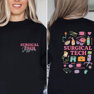 May include: Black sweatshirt with the text "SURGICAL TECH Jessica" in pink script on the front. The back features a colorful graphic with medical tools, the words "SURGICAL TECH," and other medical-related words.