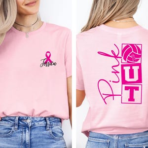 May include: Pink t-shirt with a pink ribbon and the name "Jessica" in black script. The back of the shirt features the word "Pink" in script, along with a volleyball and the letters "UT" in pink.