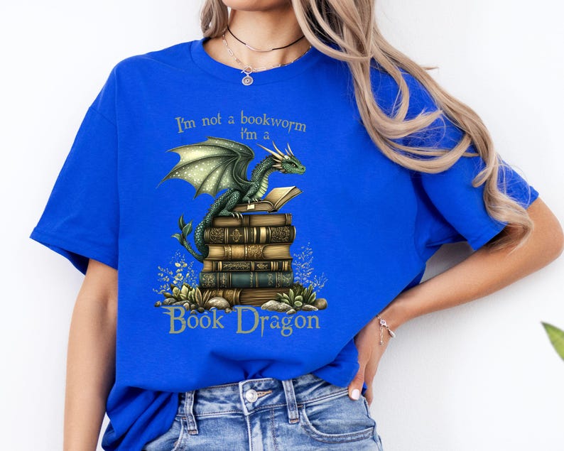 May include: A royal blue t-shirt with a green dragon sitting on a stack of books. The text on the shirt reads "I'm not a bookworm I'm a Book Dragon".