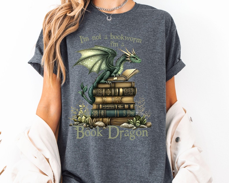 May include: A gray t-shirt with a green dragon sitting on a stack of books. The text on the shirt reads "I'm not a bookworm I'm a Book Dragon".
