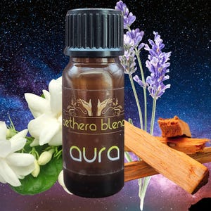 May include: A small brown glass bottle with a black cap and a white label that reads "Aethera Blend Aura". The bottle is surrounded by lavender flowers, sandalwood sticks, and white jasmine flowers against a dark blue starry background.