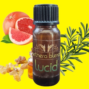 May include: A brown glass bottle with a black lid and a green label that says "ethere blends Lucid". The bottle is surrounded by grapefruit slices, rosemary sprigs, and amber-colored resin.