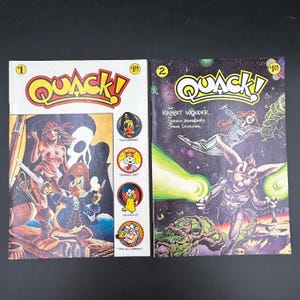May include: Two vintage "Quack!" comic books. The first features a pirate theme with a duck character, a woman, and the word "Quack!" in a yellow and red font. The second comic book cover has a space theme with a rabbit character.