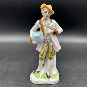 Vintage Porcelain Figurine – Boy with Bird & Parcel – Hand Painted Japan Style – Blue Anchor Mark – 6” Tall Farmhouse Shelf Decor