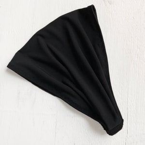 May include: A black stretchy headband made of soft fabric.