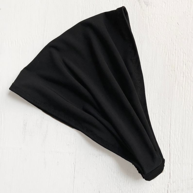 May include: A black stretchy headband made of soft fabric.