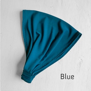 May include: A blue fabric headband, folded and ready to wear. The headband is made of a soft, stretchy material.